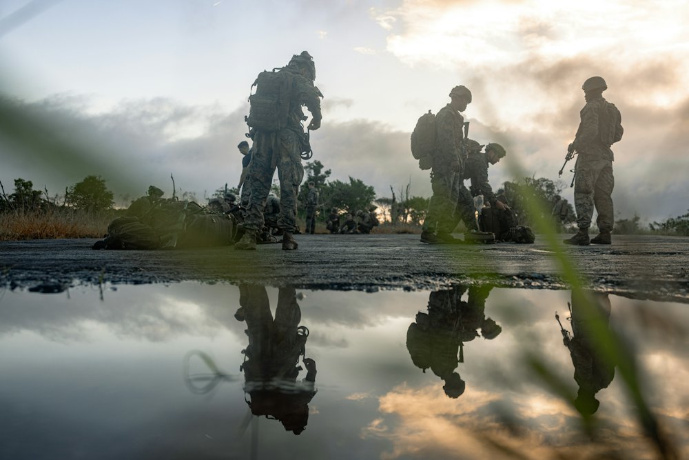 A squad of soldiers at dawn, reflected in water